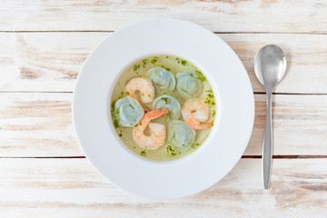 Soup dumplings and shrimp served with leek. On old wooden white background.