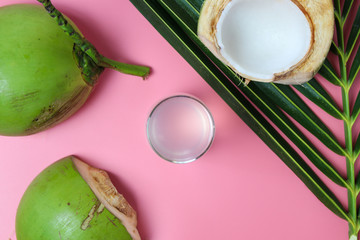 Fresh  coconut water in glass Ready to drink with leaf on  pink background, summer and healthy concept. 