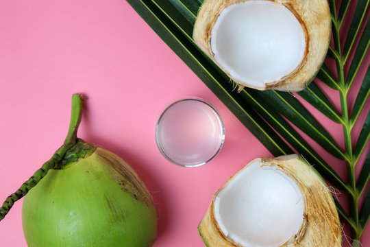 Fresh  coconut water in glass Ready to drink with leaf on  pink background, summer and healthy concept. 