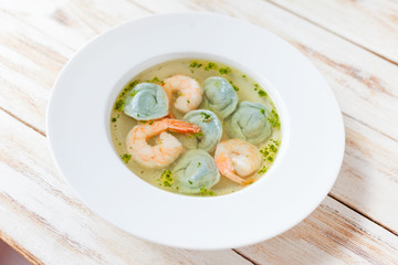 Soup dumplings and shrimp served with leek. On old wooden white background.