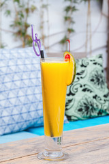 Glass of orange juice on wooden table