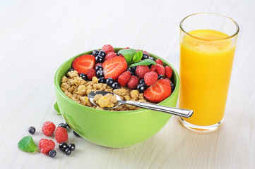 Muesli with fresh berries in a bowl on a light background.