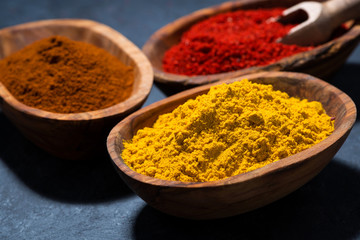 ground spicy paprika, turmeric and red pepper in a wooden bowl