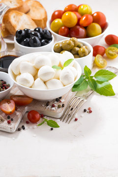 ingredients for salad with mozzarella on white background, vertical