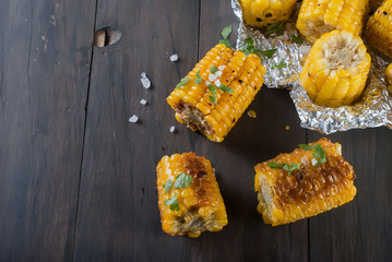 corn grilled on a wooden kitchen board with salt © vimart
