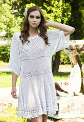Naklejka premium The girl in a white dress, poses in a garden
