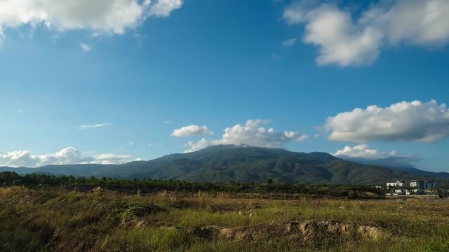 Beautiful scene of fluffy clouds moving behind the mountain - Timelapse , 4k