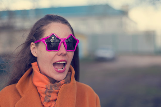 Young smiling woman with vivid emotions in sunglasses in the form of a star