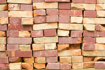 Obraz premium Old clay bricks stacked in the wall as a background.