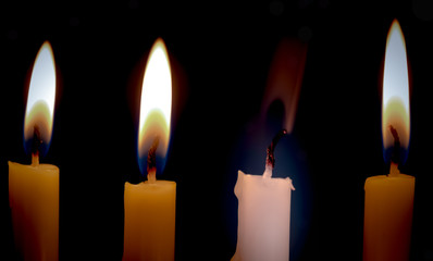 Extinguished candle among burning ones with smoke over dark background. Standing out from crowd...