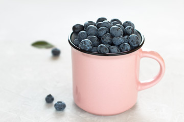 Summer healthy snack blueberry in a cup on the table.