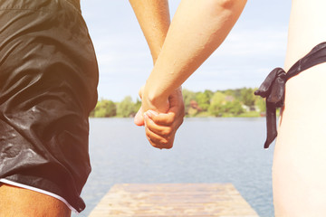 Couple holding hands about to jump in the water