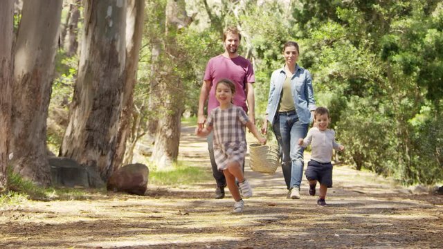 Family Walking Along Path Through Forest Together