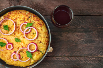 Spanish tortilla in tortillera with red wine and copyspace