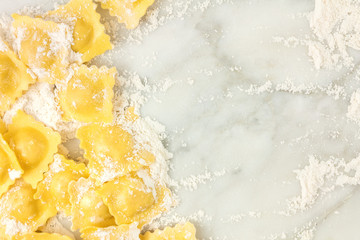 Overhead photo of ravioli with flour and copy space