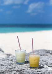 Colorful drink on the beach. Sunny and hot day. Refreshing cold cocktail with a straw. Focus point on the drink.