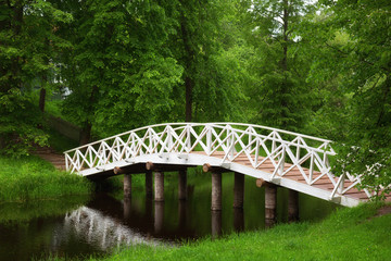 White wooden bridge in the old park in the village of Mikhailovskoye, Pskov region, Russia