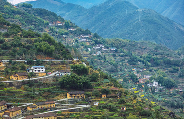 Fototapeta na wymiar Scenic View Of Village Field And Mountains.