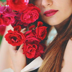 the girl holds a bouquet of red roses, a gift for a St. Valentine's Day, a portrait