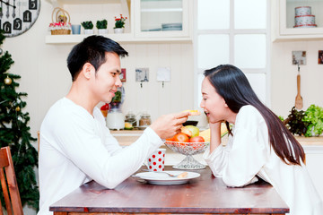 Couple having breakfast together at home in kitchen
