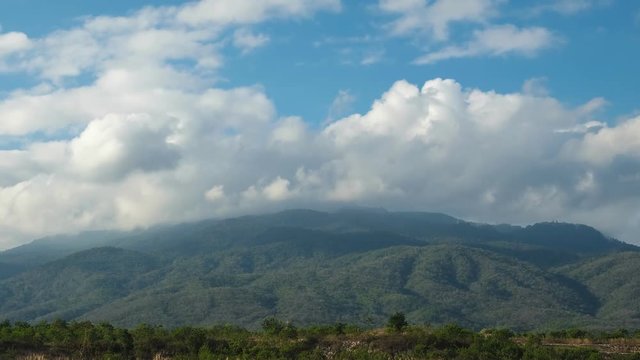 Beautiful scene of fluffy clouds moving behind the mountain - Timelapse , 4k