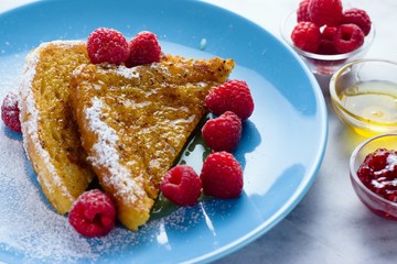 French toast served with raspberries, jam and honey