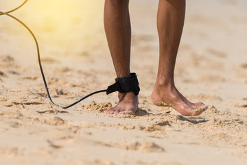 Asian young surfer with leg rope walking on the beach..Sunny day and big wave,paradise of surfer.