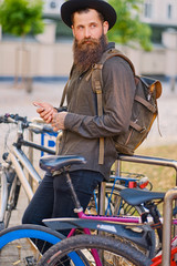 A man with backpack near city bicycle parking.