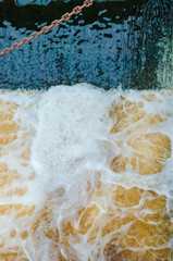 Water with foam. Abstraction for background. A small waterfall. Movement of water.