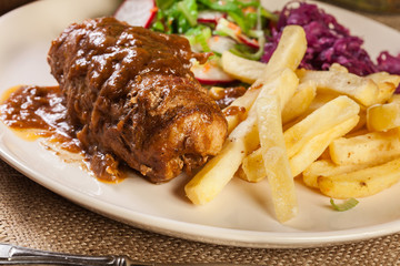 Pork roulade with french fries with salad