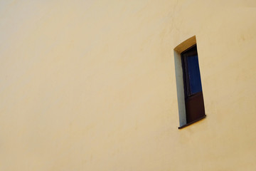  narrow window in the wall of an old house
