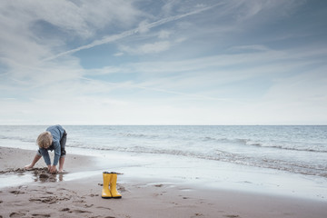 Boy playing on beach with sand