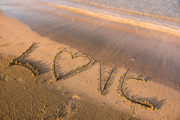 Fototapeta na wymiar Love word written in sand