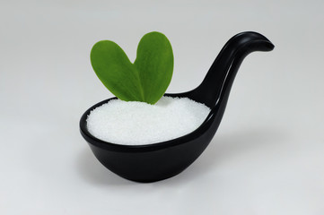white sugar  on black spoon