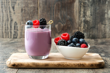 Healthy berry smoothie in glass on wooden table
