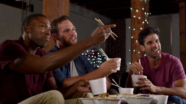 Three male friends eating a Chinese take-away watching TV, shot on R3D