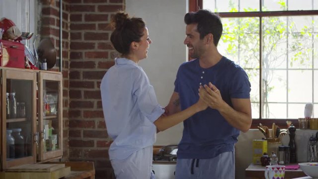 Happy Hispanic couple dancing in kitchen in the morning, shot on R3D