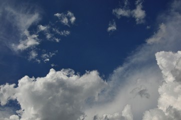 Puffy white clouds on navy-blue sky