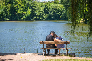 Couple in love on a bench near a lake