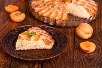Piece of apricot cake on wooden table.