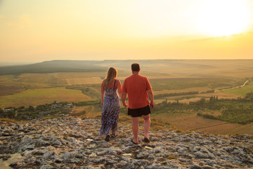 Loving couple on a rock top.