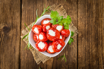 Red Pepper (stuffed with cheese) on wooden background (selective focus)