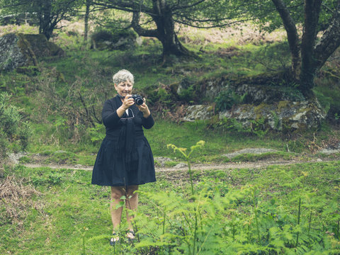Senior woman taking photos in nature