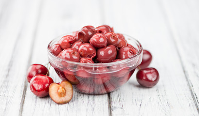 Portion of Canned Cherries on wooden background, selective focus