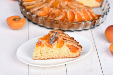 A piece of apricot pie decorated with a sprig of lavender.