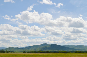 Fototapeta premium Field, hills and clouds