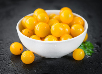 Some Yellow Tomatoes on a dark slate slab