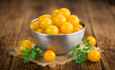Wooden table with Yellow Tomatoes, selective focus