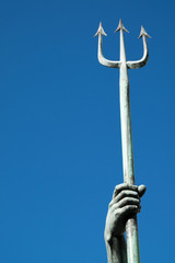 Trident spear being held aloft by bronze statue hand