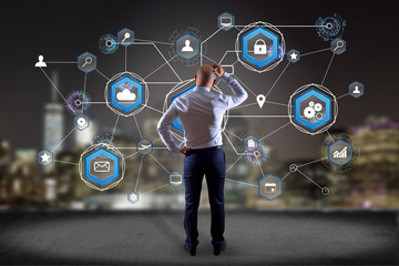 Businessman in front of a wall with an International business network connection displayed on a futuristic interface with technology icon and sphere globe - Worldwide business concept